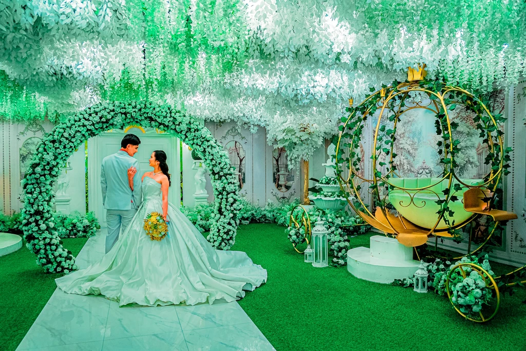 Bride and groom beside the fairytale carriage under the floral arch at Celestia Hall