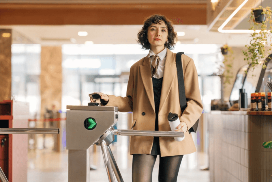 a professional woman passing through an office turnstile