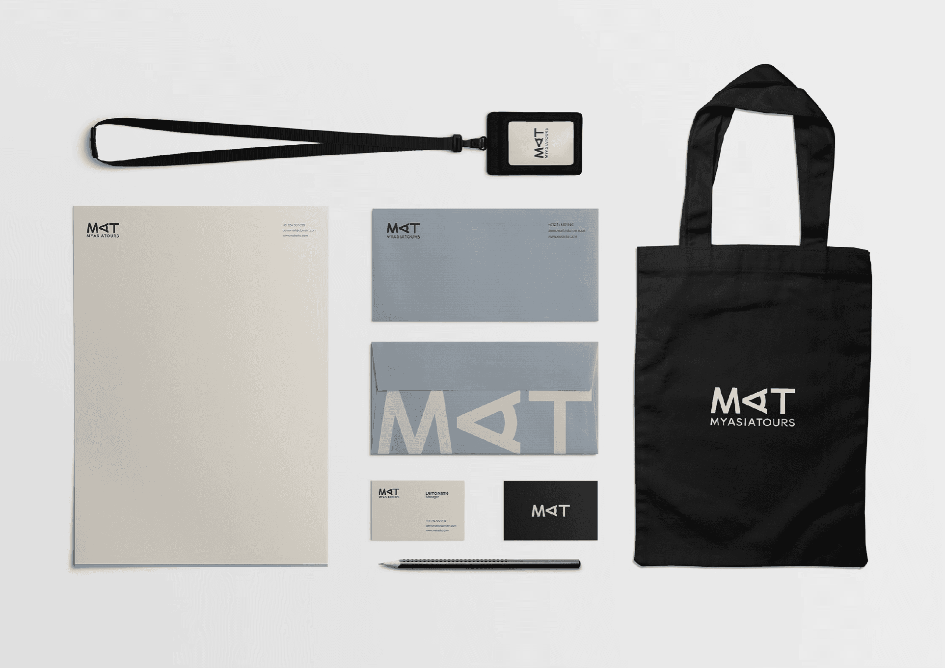 MyAsiaTours 品牌識別應用物俯拍，信紙信封名片頸掛繩與黑色托特包排列
