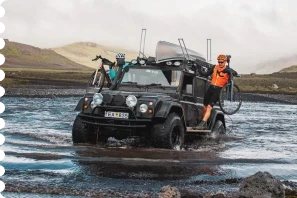 Car with people and bikes coming out of lake