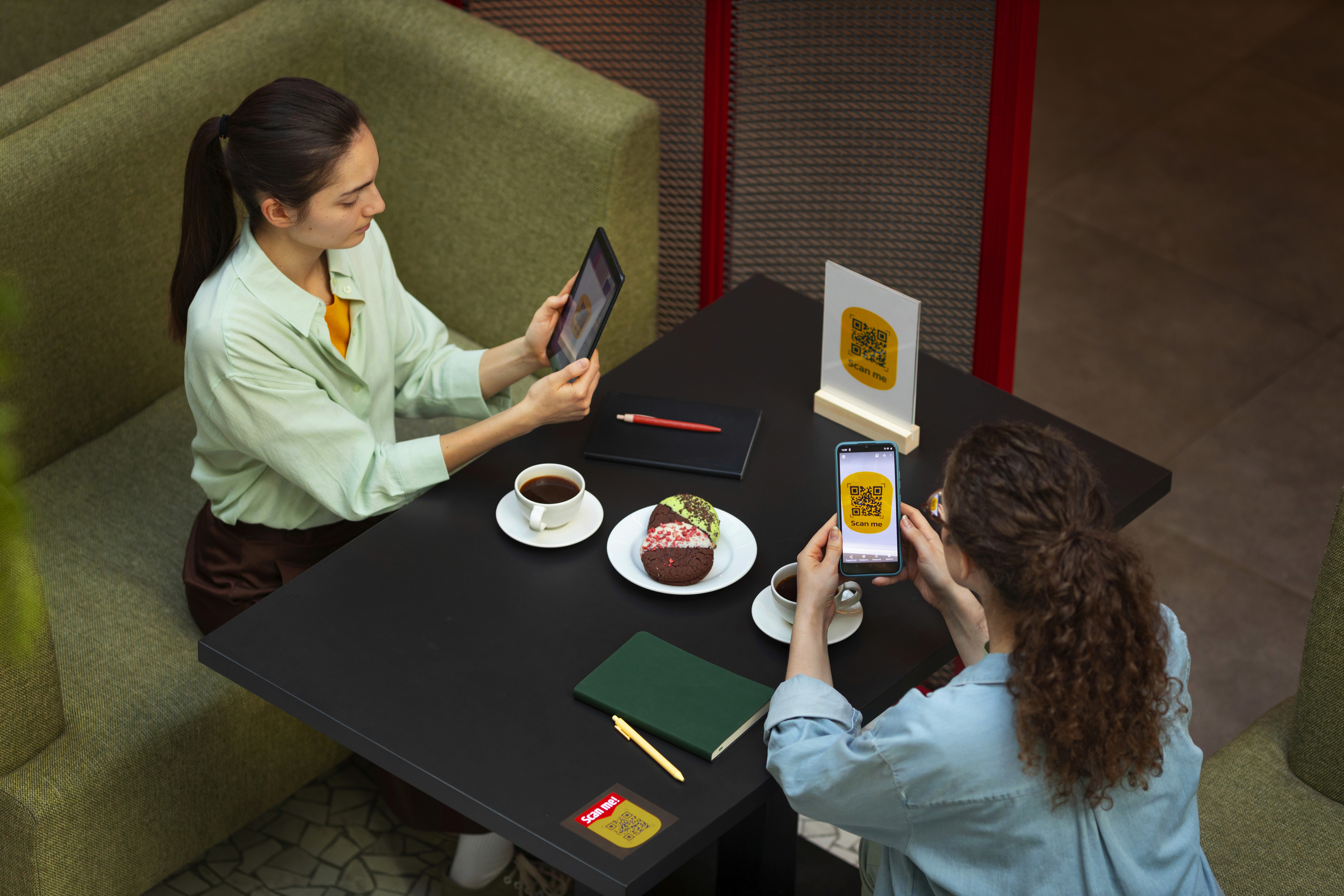 Focused woman working on a laptop in a cozy, dimly lit café with a tea glass on the table.