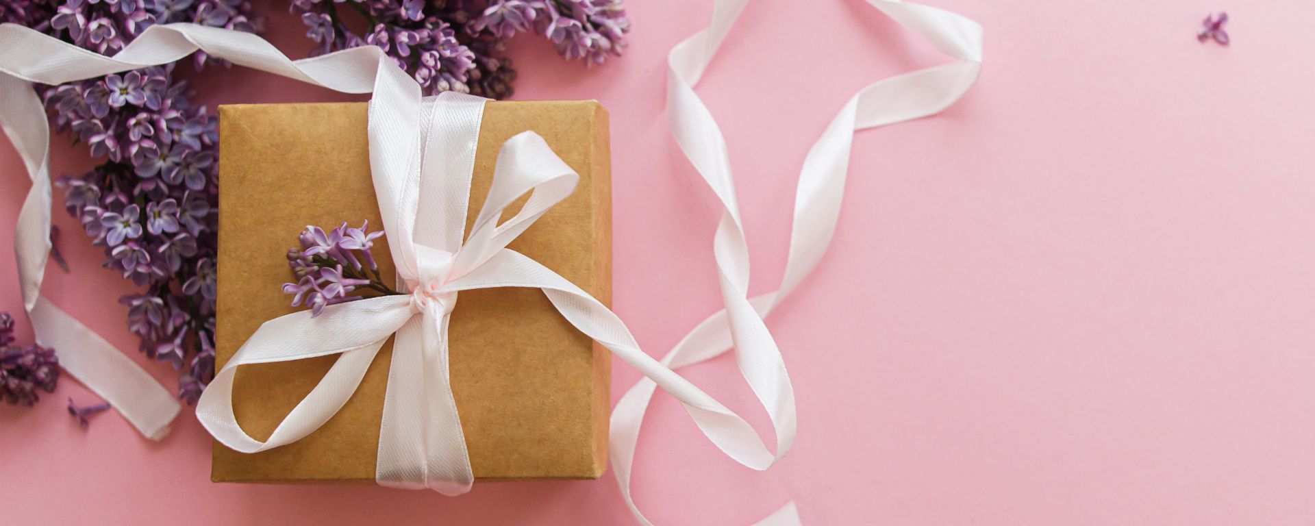 A couple joyfully celebrates in front of a rustic stone building.