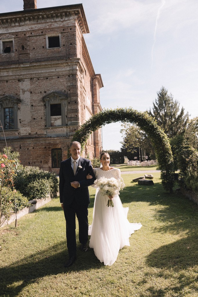 Cerimonia nuziale degli sposi sotto arco floreale in giardino - matrimonio Rebecca e Giorgio a Villa La Favorita