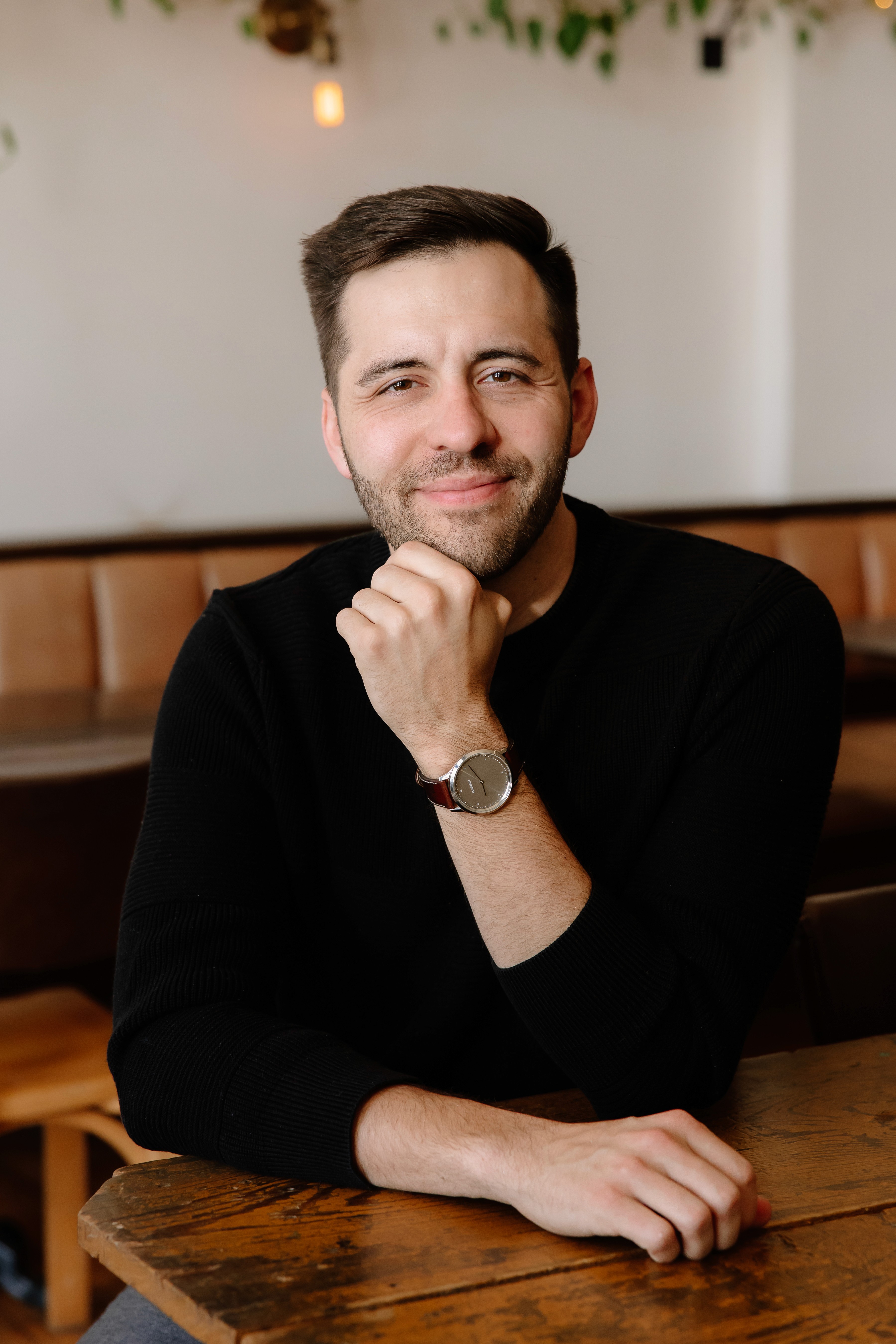 Close-up of a scientist holding a tray of petri dishes with purple cultures, wearing gloves and safety gear.