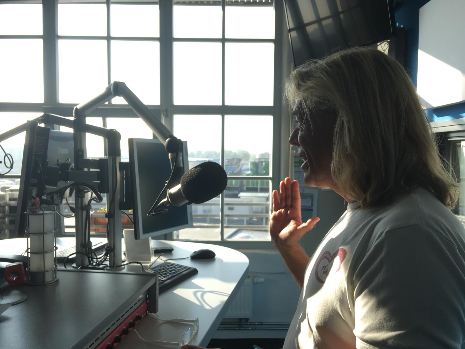 Seitenaufnahme: Marcel Combé spricht im Radiostudio in ein Mikrofon.