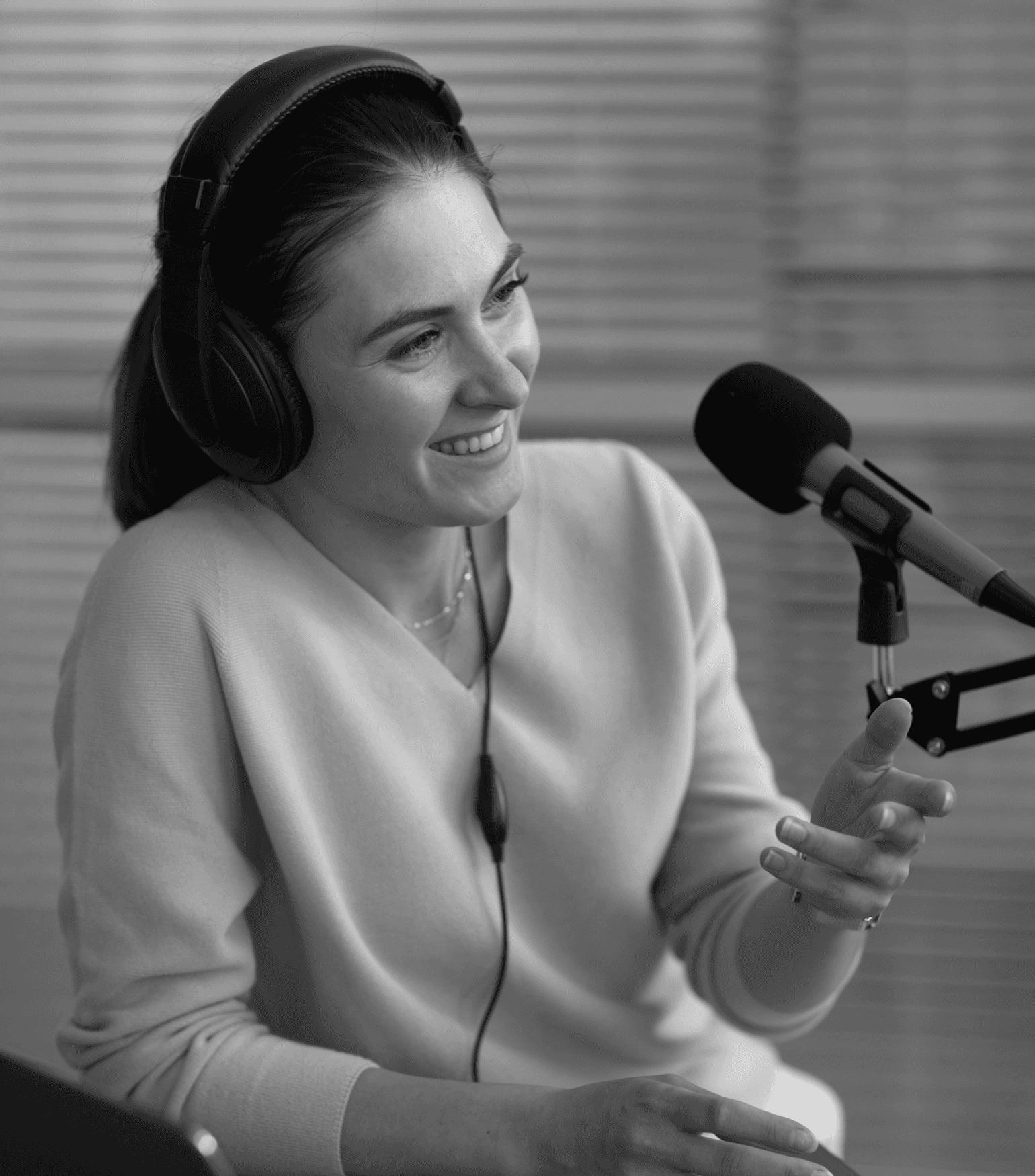 Female podcaster talking into a microphone.