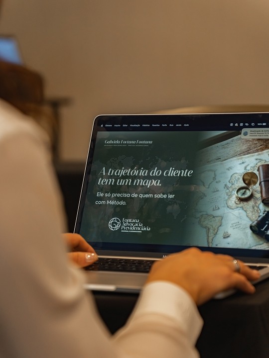 Participante acompanha a apresentação no notebook em evento da University Seal