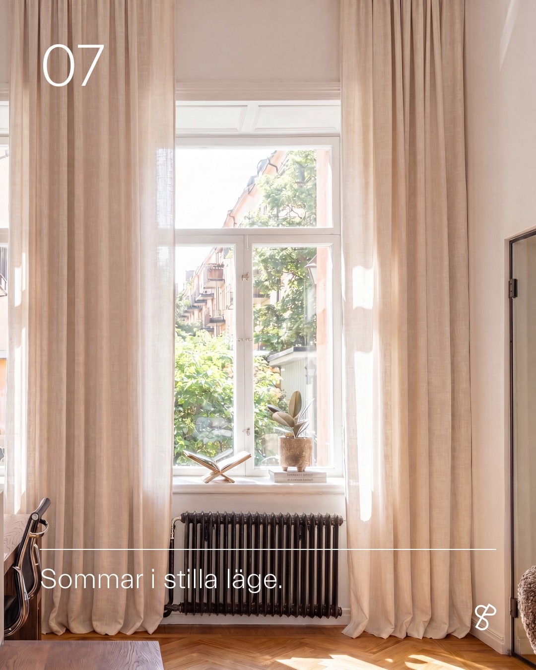 An open office window framed by curtains with the campaign line Sommar i stilla läge.