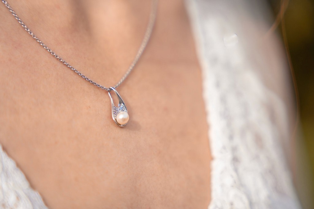Nahaufnahme einer silbernen Halskette am Dekolleté der Braut bei Hochzeit