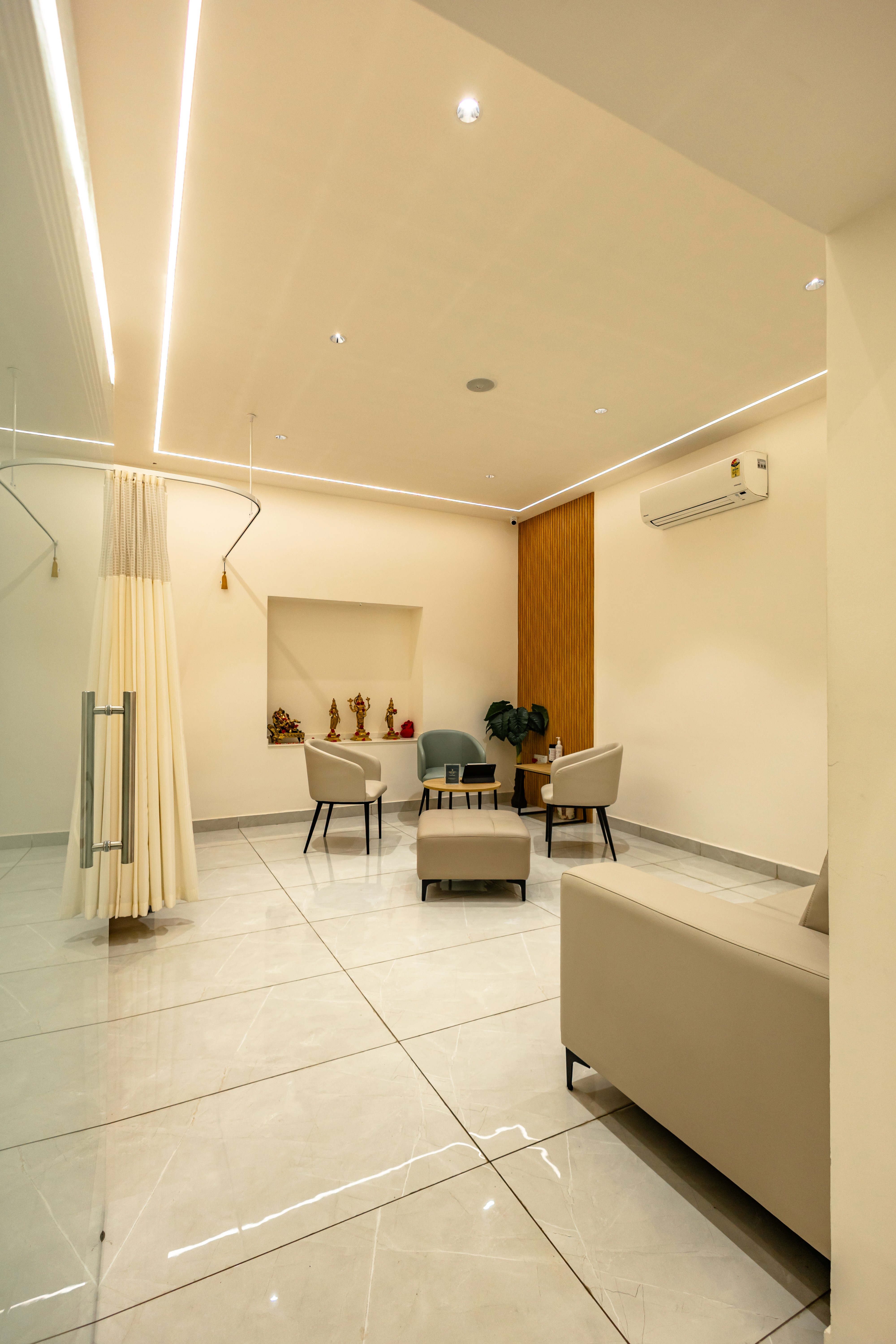 Elegant white waiting room at Seren Med Lounge with an orange sofa set, three chairs, and a center table creating a premium and welcoming ambiance.