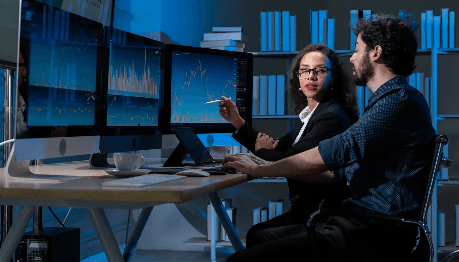 Colleagues analyzing data on monitors - Enterprise Customer Data Platforms