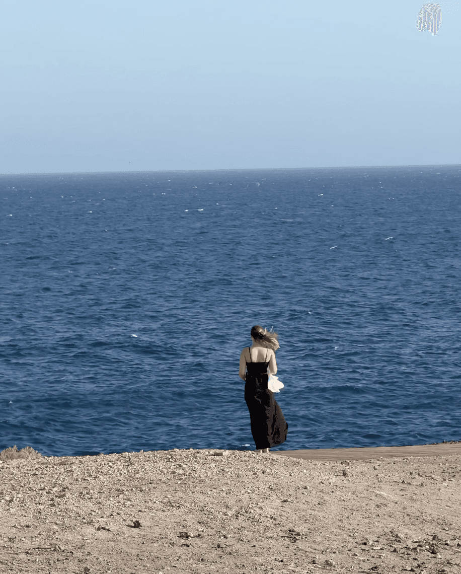A smiling woman writing on a piece of paper in her home