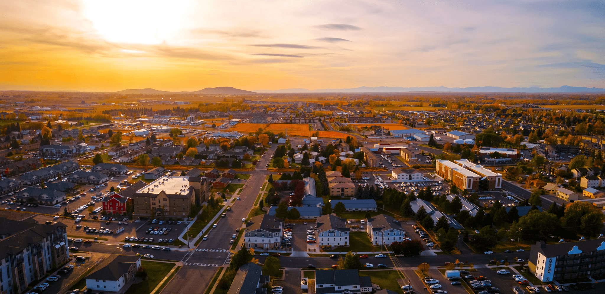 Aerial view of town at sunset with mountains in distance