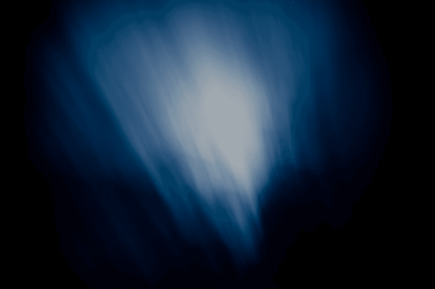 An abstract image with soft, blurred blue light fading into darker tones.