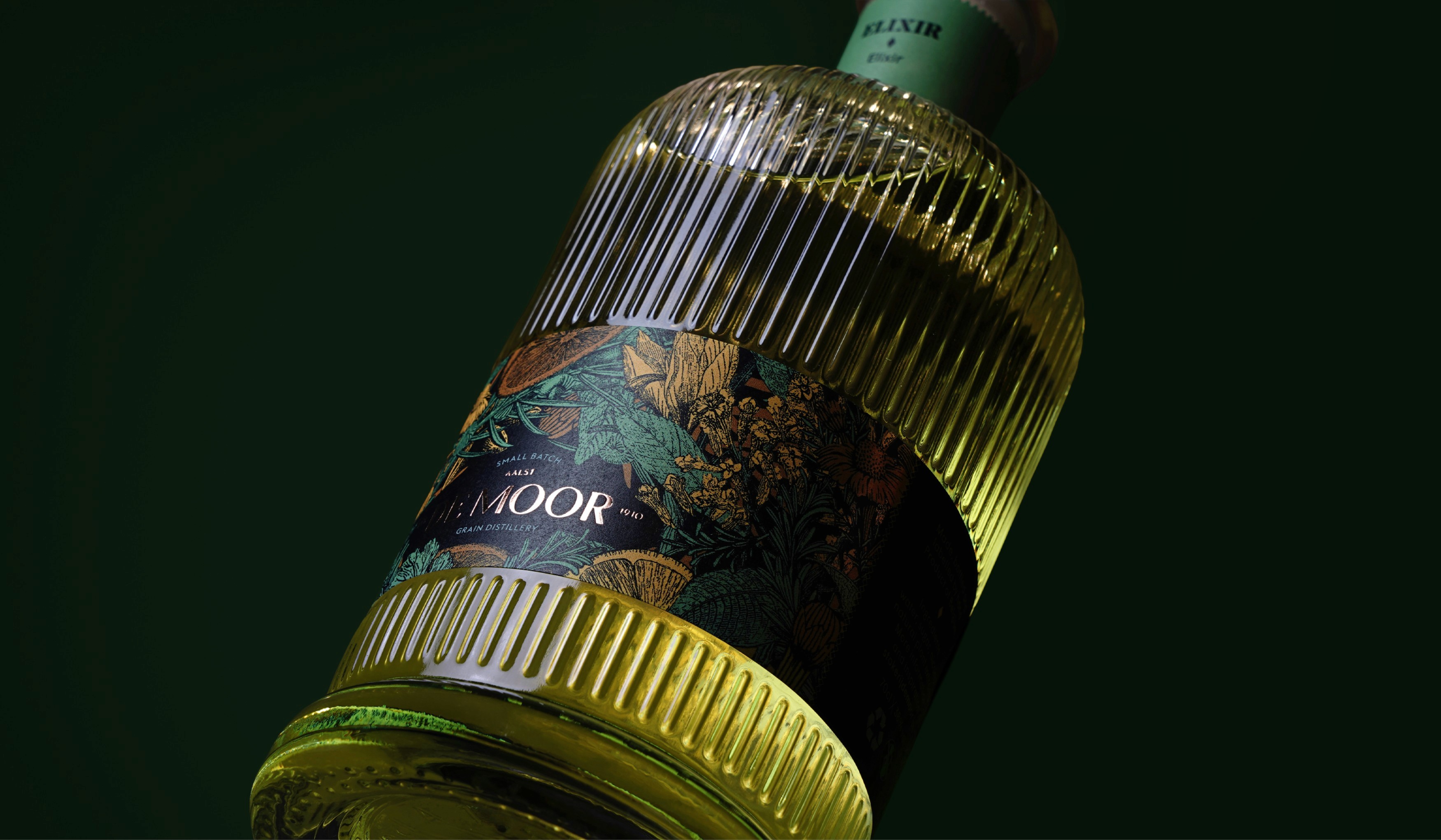 Ribbed De Moor liqueur bottle with a botanical label, lit against a dark green background