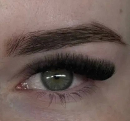 Pose d’extensions de cils sur œil vert – effet dramatique et courbure prononcée pour un regard glamour et sophistiqué.