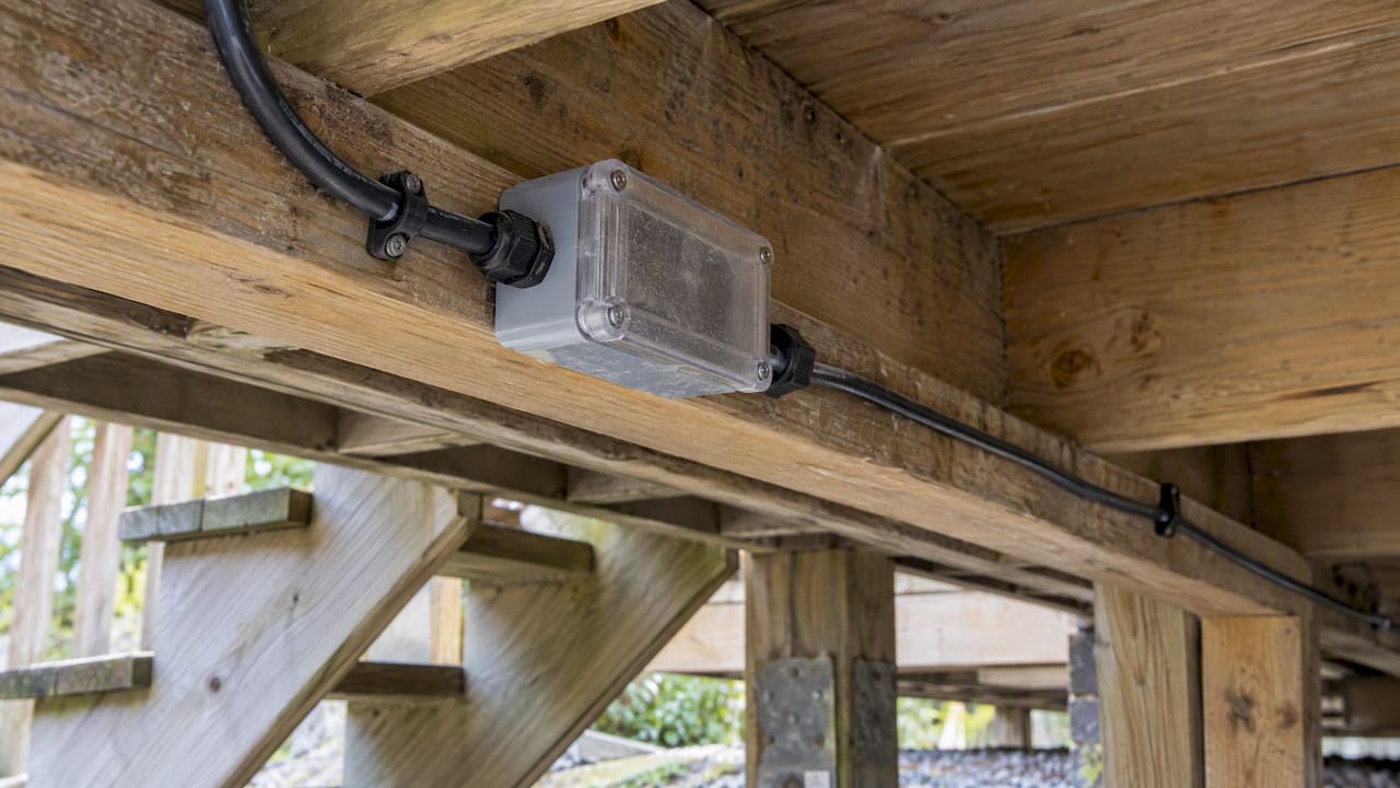 Enclosed lighting connection beneath deck stairs
