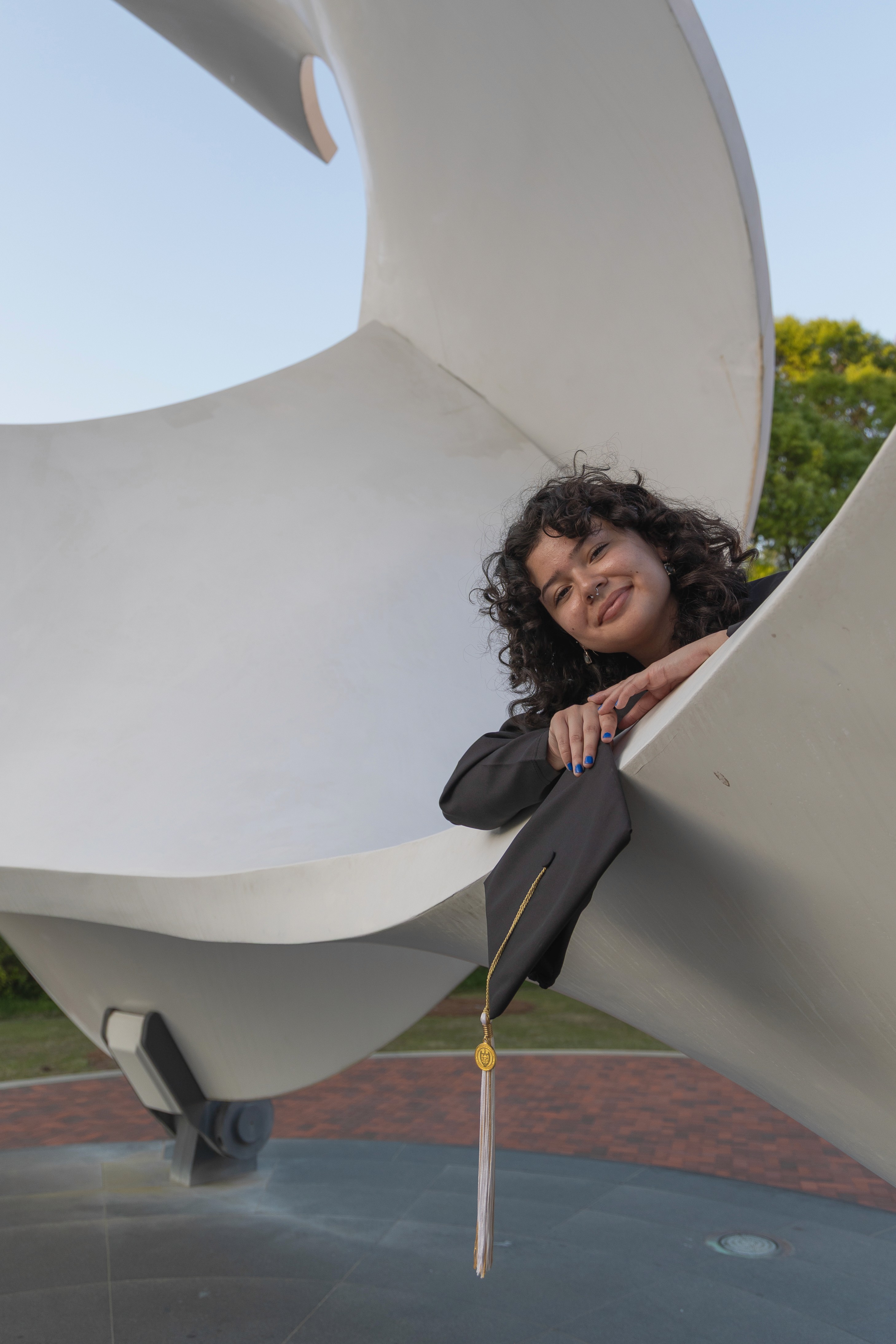 unique nontraditional graduation portraits with cap and gown with tech tower in the background at the architecture building