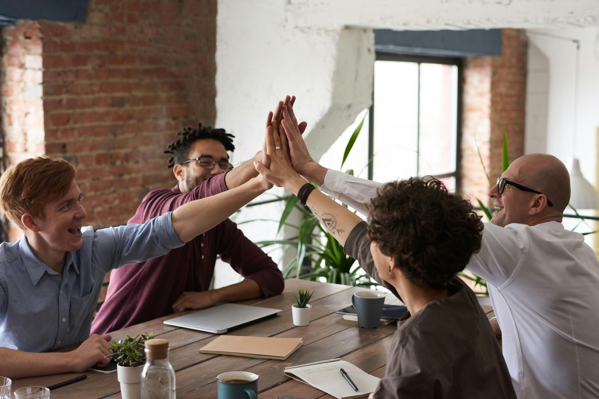 Office colleagues high-fiving each other while working.