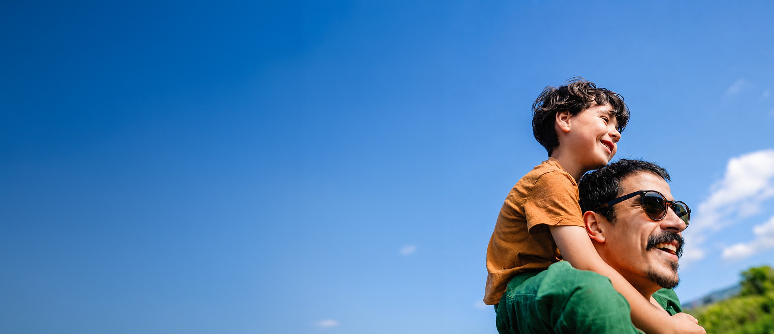 father holding son on shoulders
