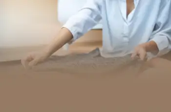 Person folding dark fabric on table