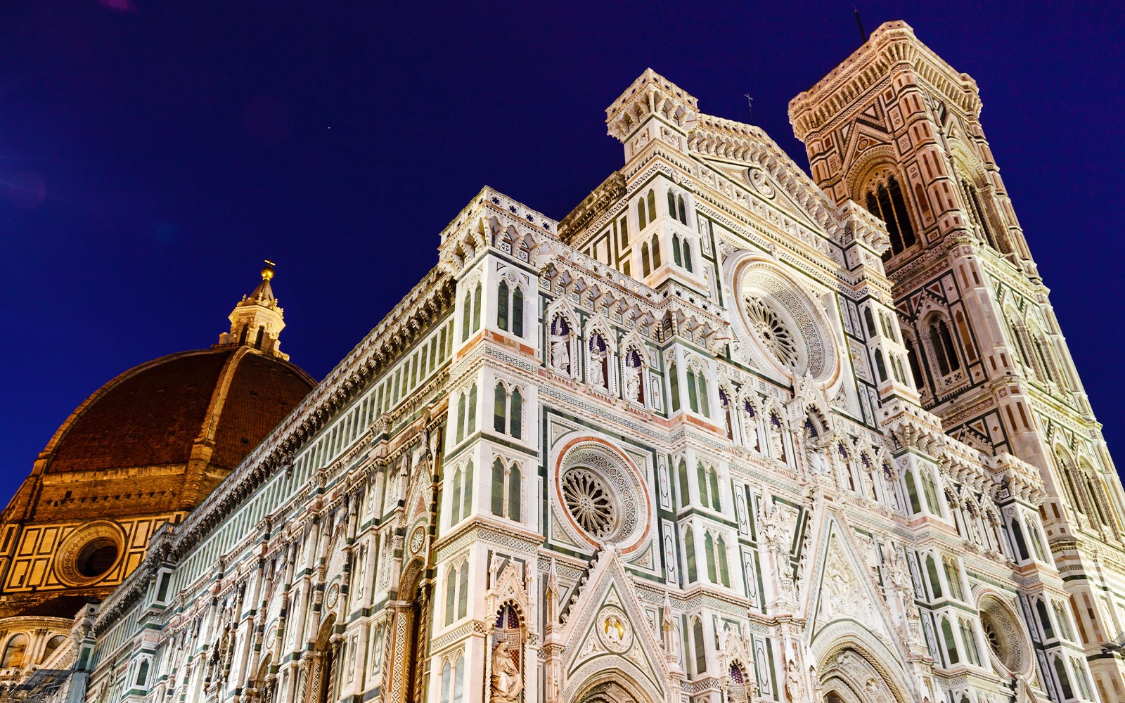 在电子自行车夜间游览期间，从米开朗基罗广场观看夜幕下灯火辉煌的佛罗伦萨大教堂。