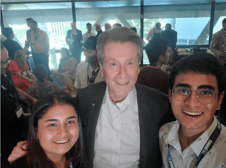 Close-up of lush, dark green leaves, some glossy and wet, against a muted background.