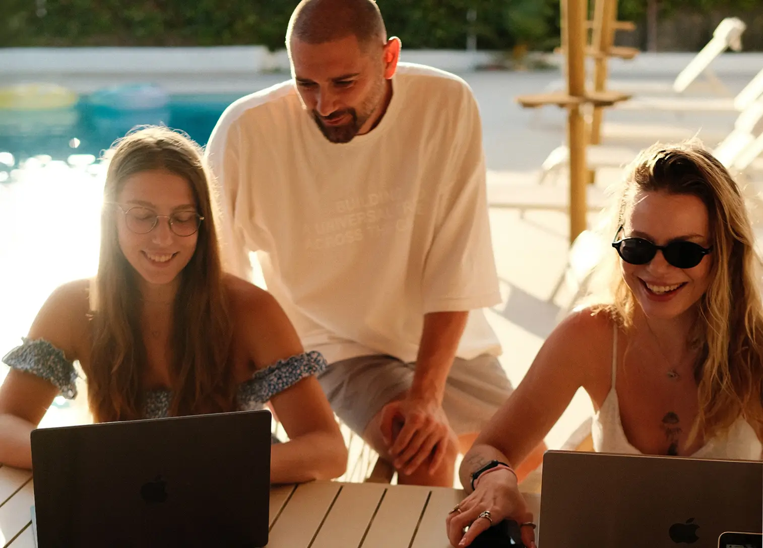 A large group photo of diverse team members gathered in an industrial-style space with arched ceiling.