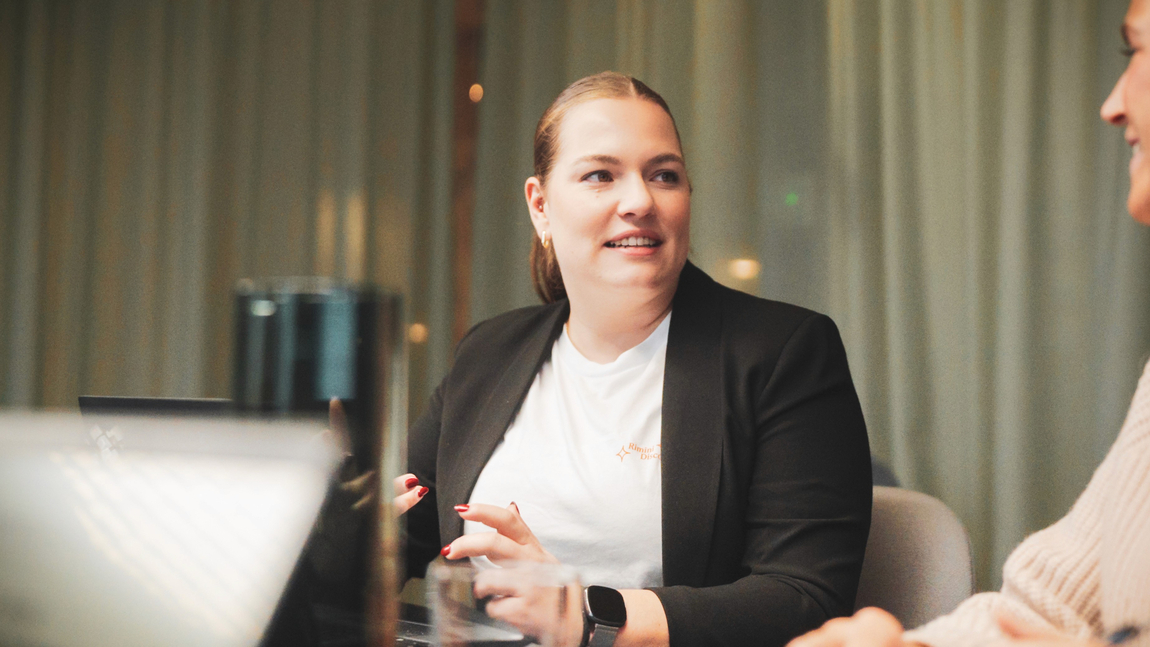 Kollegin im Gespräch mit einem Kunden oder Partner. Ausdruck für Beratungskompetenz, Teamgeist und professionelle Kommunikation.