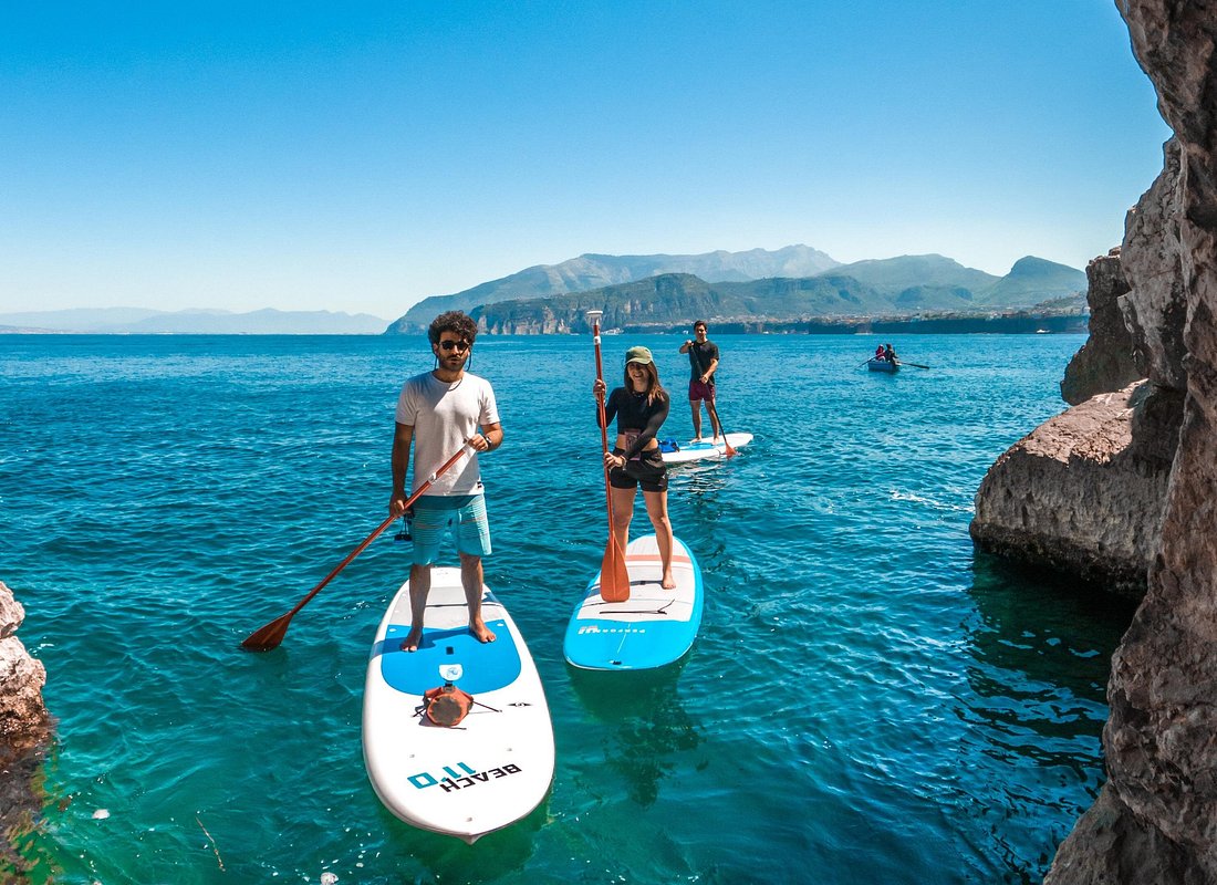 A man stading with Surfboard