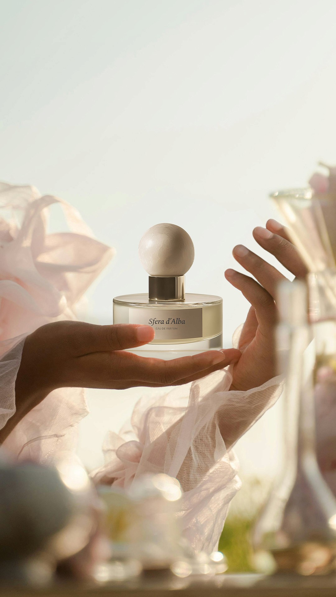 View of the French countryside through a stone villa’s open living room, with sofas and trees framing the scene