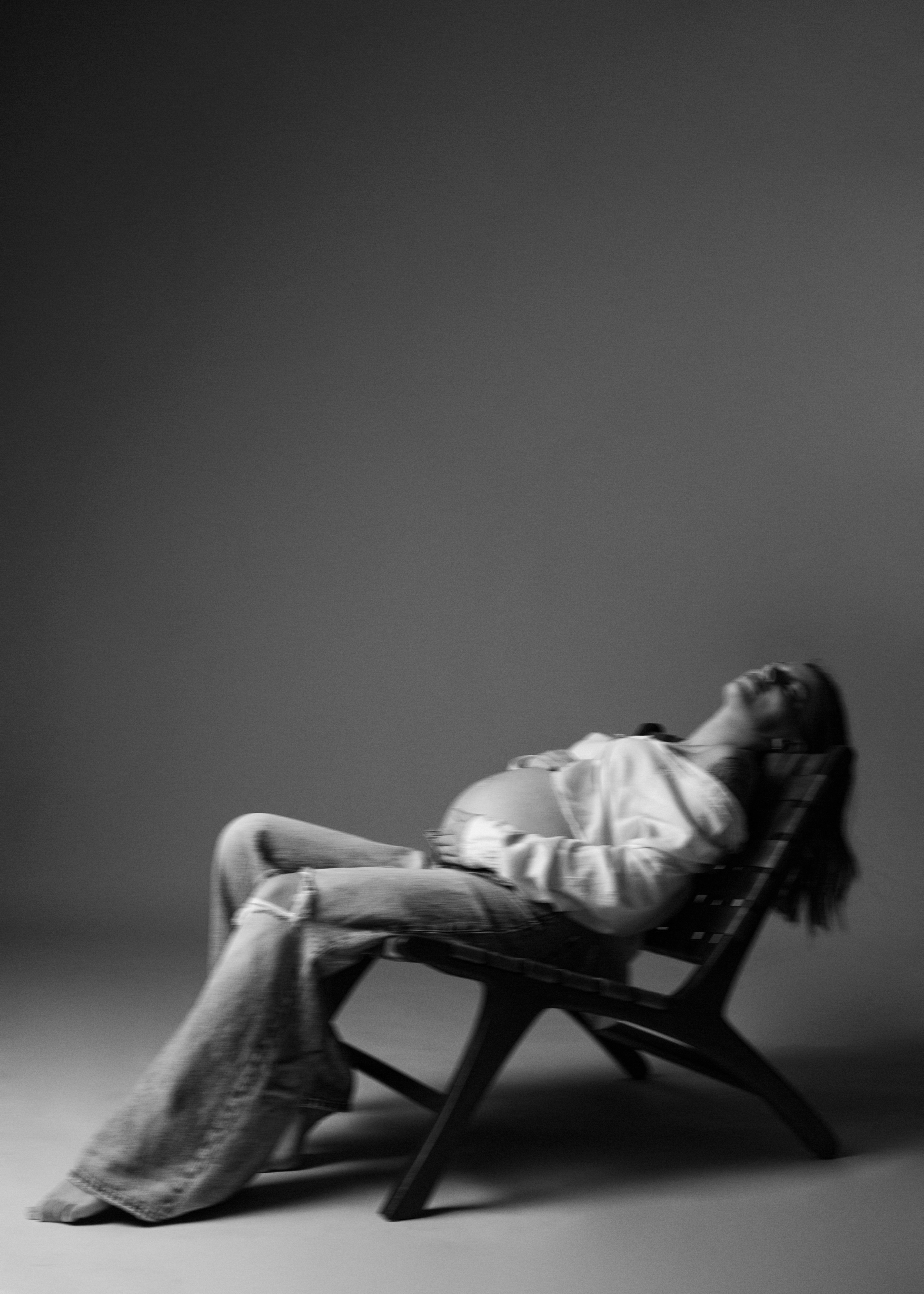 Black-and-white photo of a woman reclining in a lounge chair
