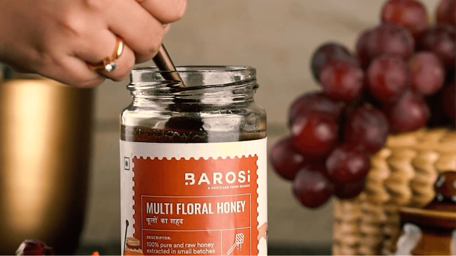Image of a jar of honey being opened with a spoon featured in a food and beverages video.