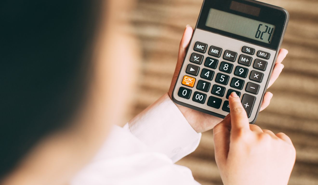 Imagem mostra calculadora na mão de uma pessoa