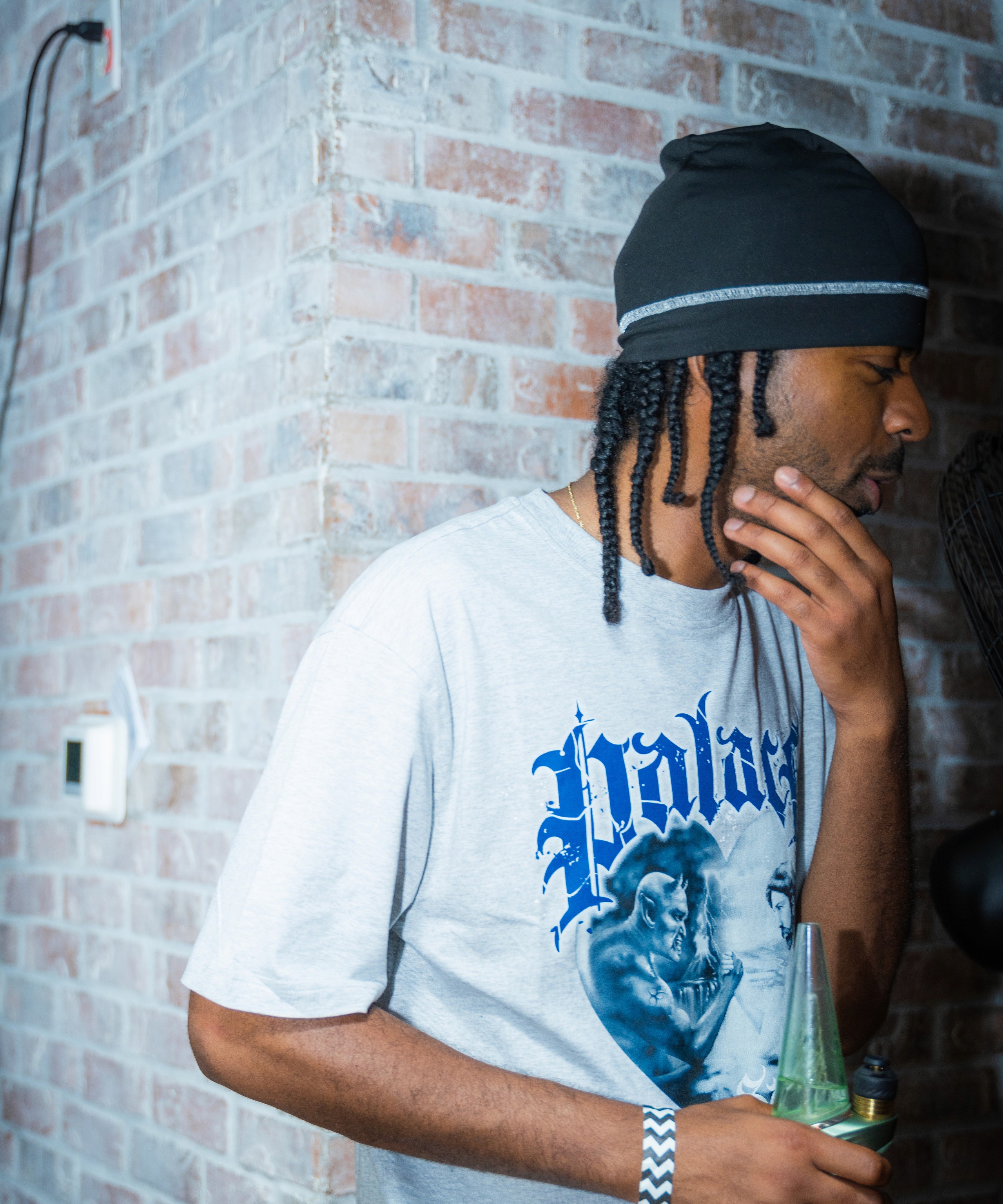 A$AP P on the Boards, music producer for A$AP Mob, stands by a brick wall, reflecting on his journey and collaborations with A$AP Rocky, A$AP Ant, and A$AP Twelvyy in an exclusive interview.