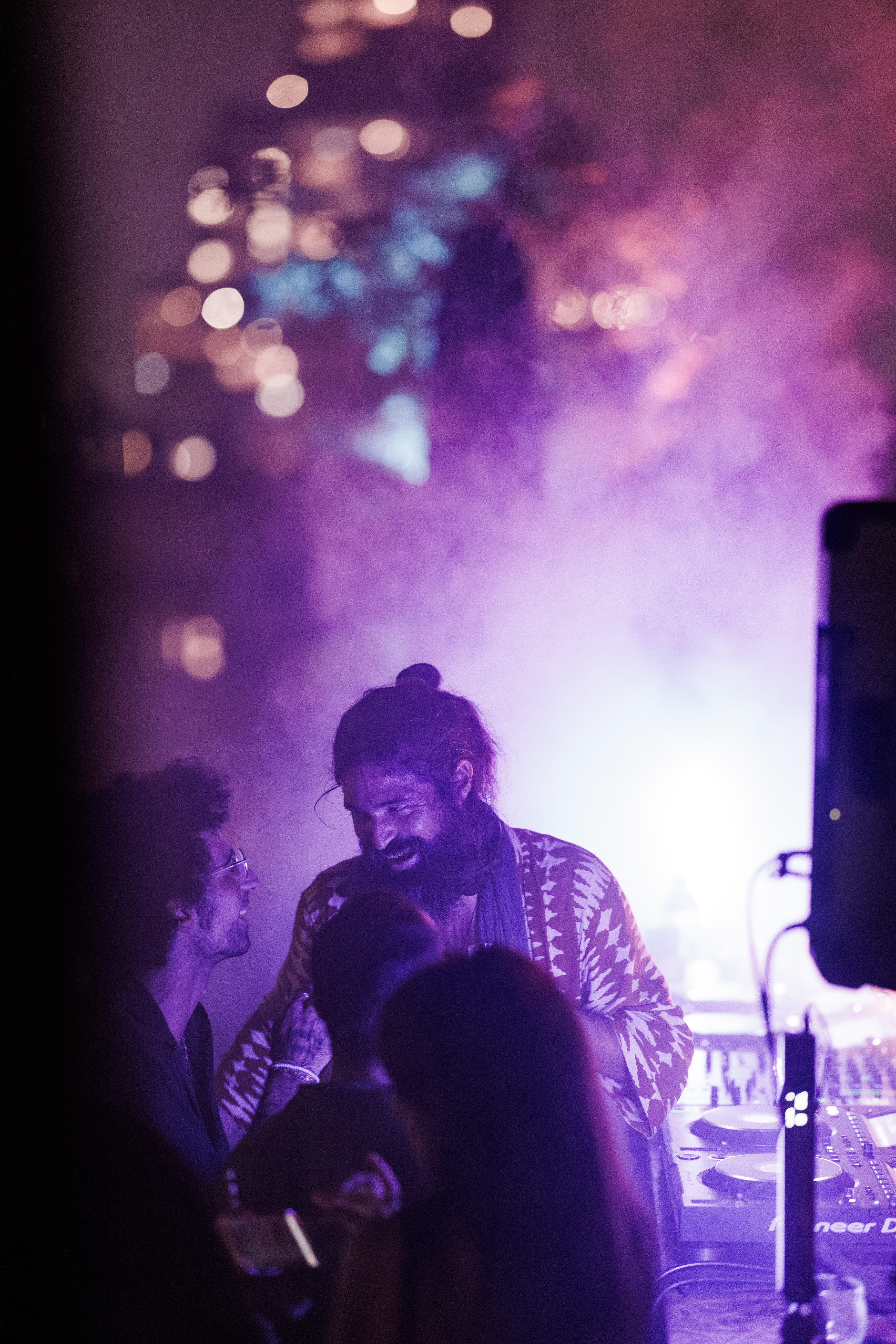 Full moon rising over a dark, silhouetted mountain ridge.