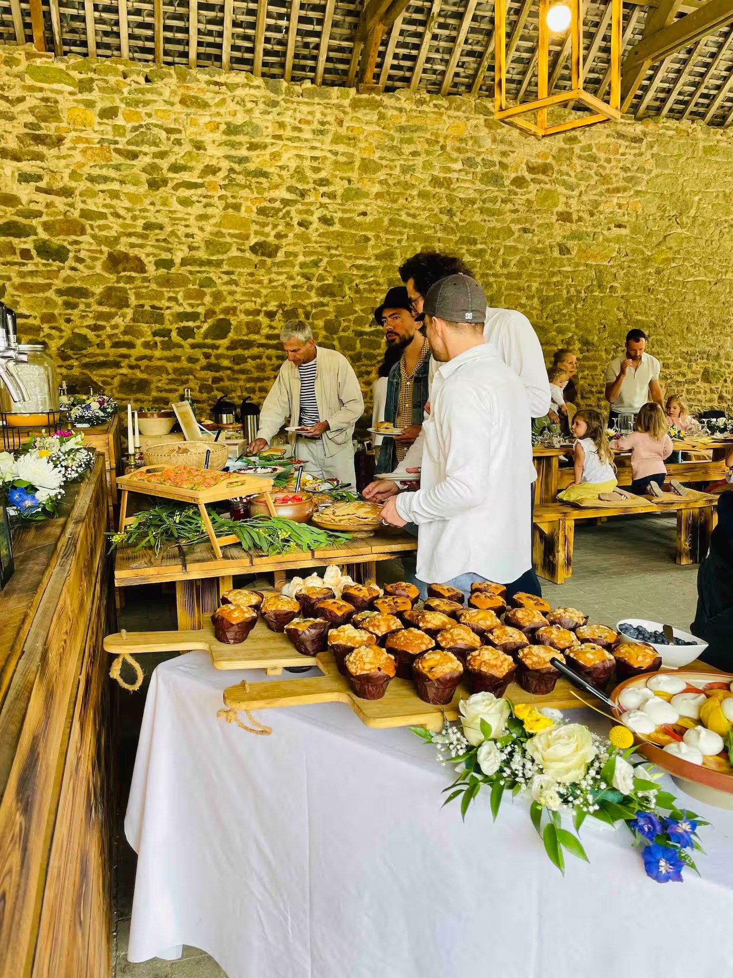 A beautifully set dining table with white tablecloth, cutlery, and fresh greenery in a cozy, well-lit space.