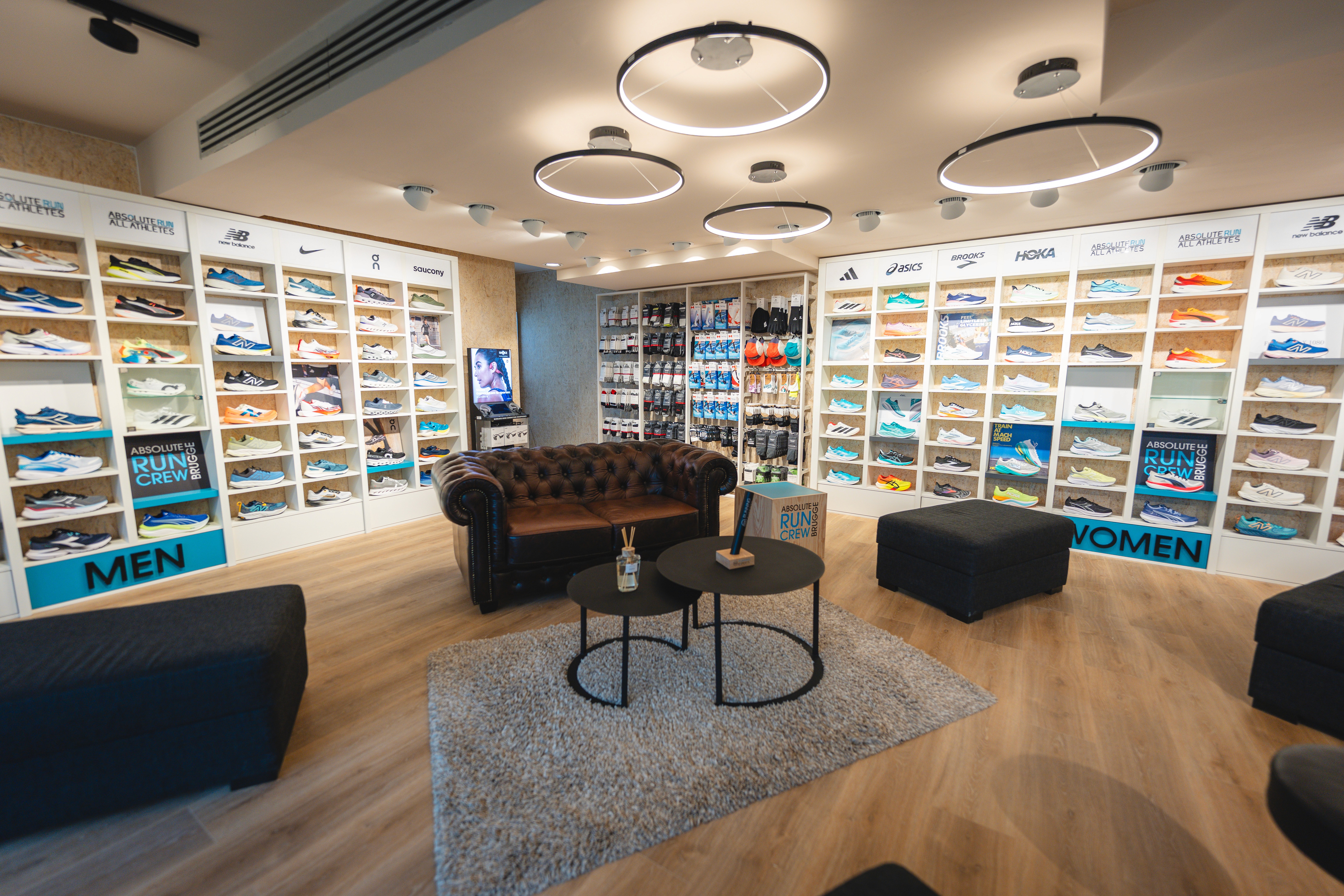 Three people in conversation with warm lighting, including a person wearing a hat and another person wrapped in what appears to be a textured shawl or sweater.