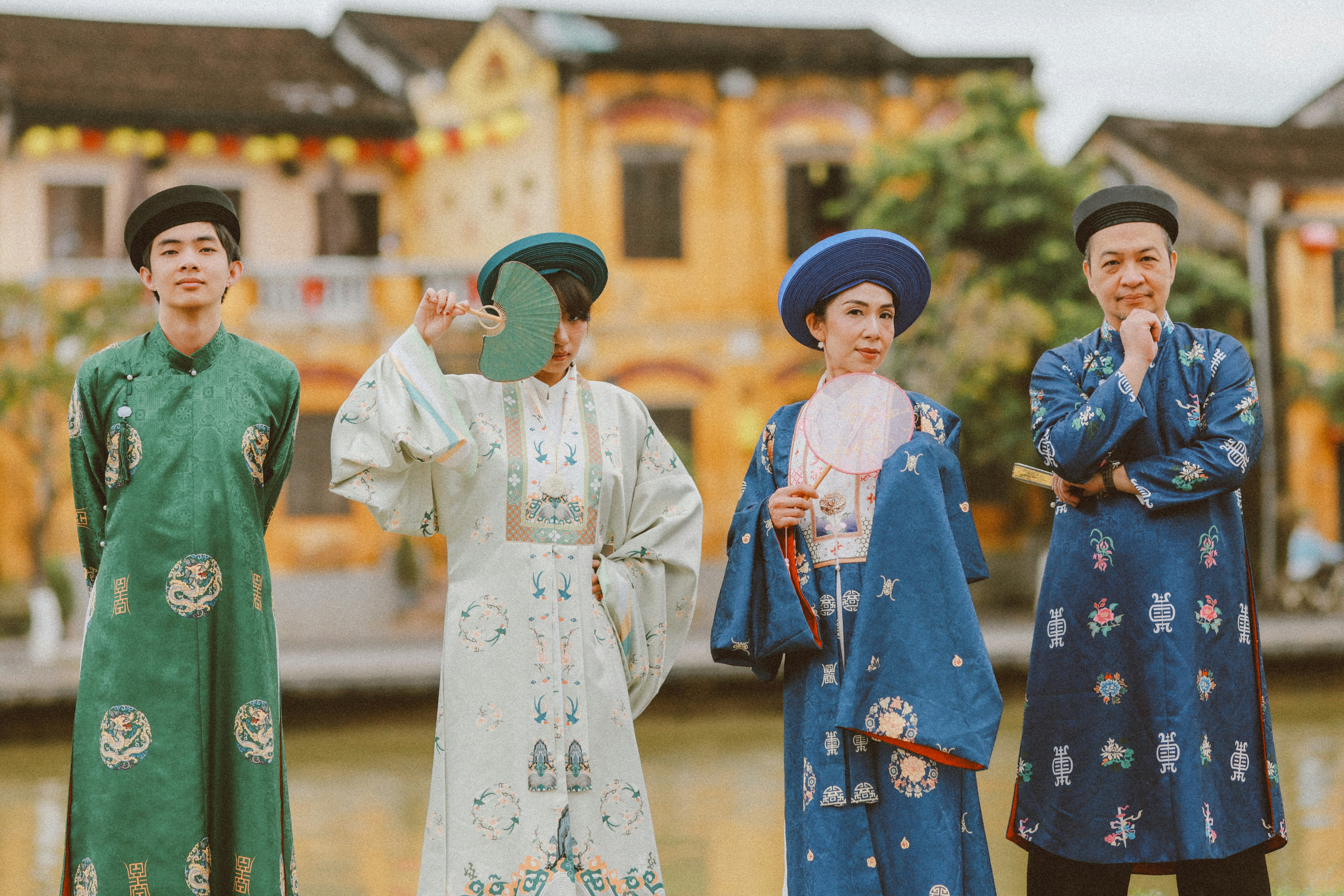 Four people in traditional vietnamese ao dai outfits