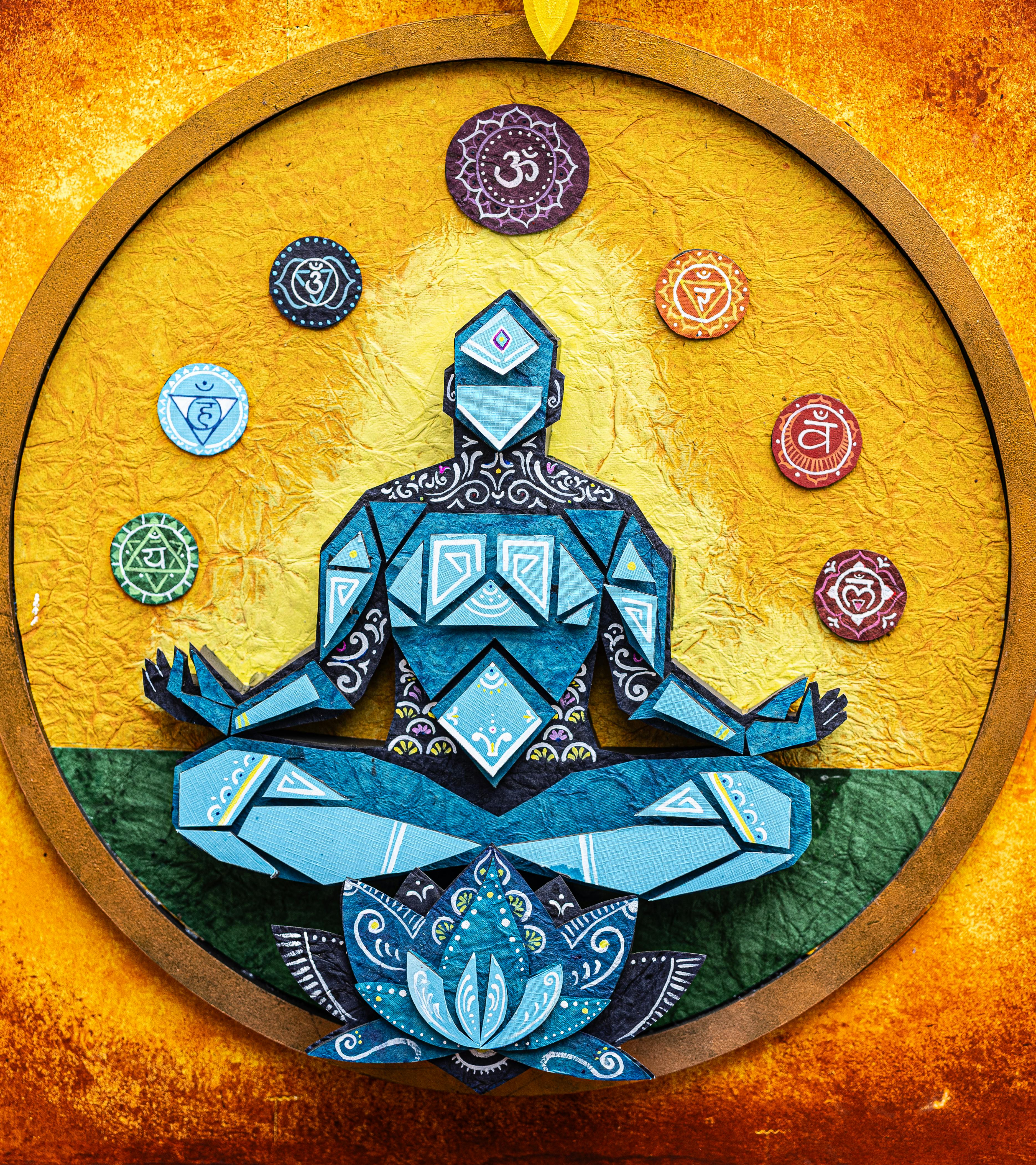 Illustration d'une figure en méditation avec les chakras représentés sur fond doré