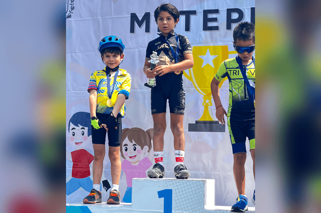 Podio infantil: niños con medallas y trofeos vistiendo uniformes de equipo.