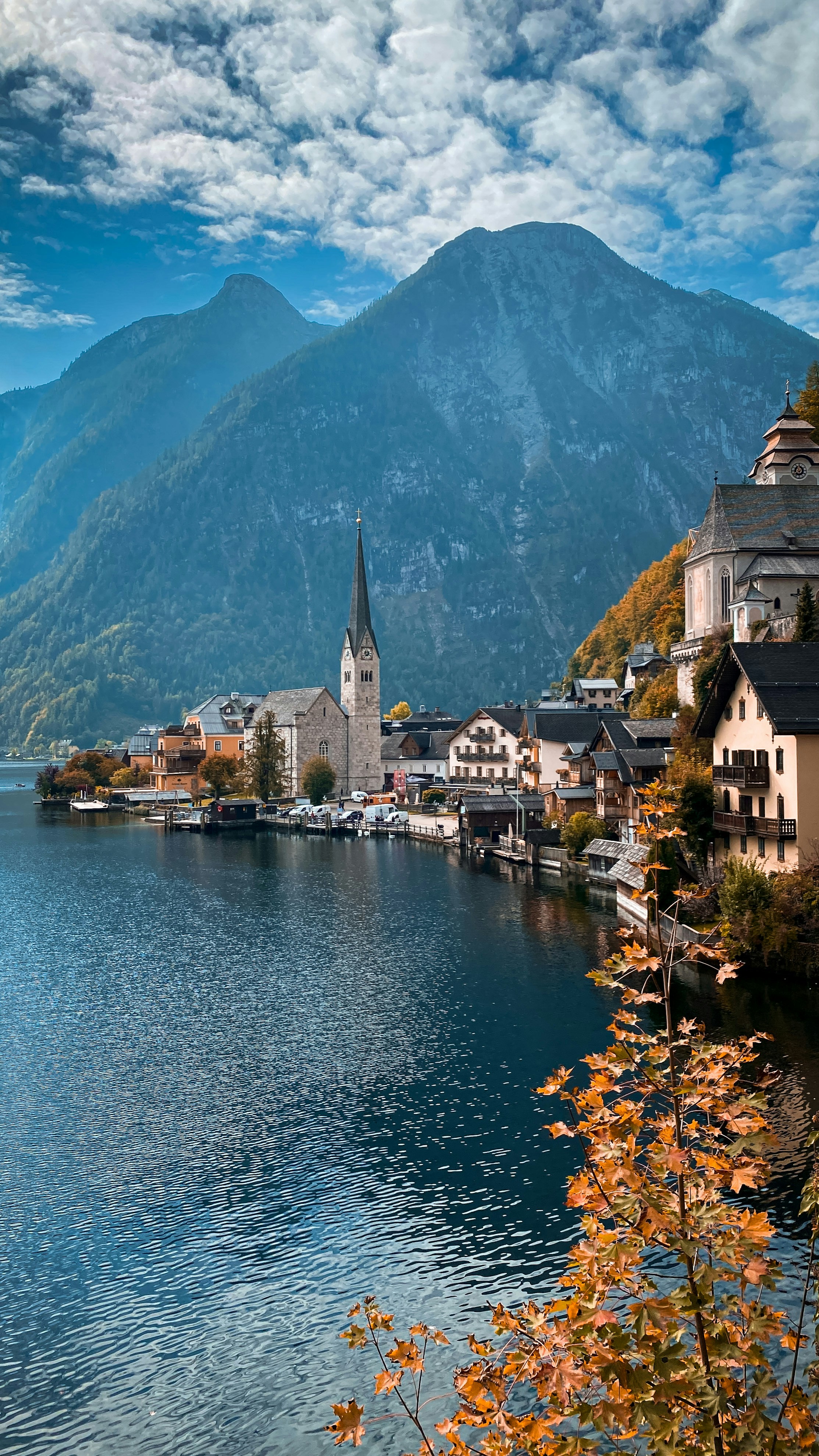 a scenic view of a town on a lake with mountains in the background