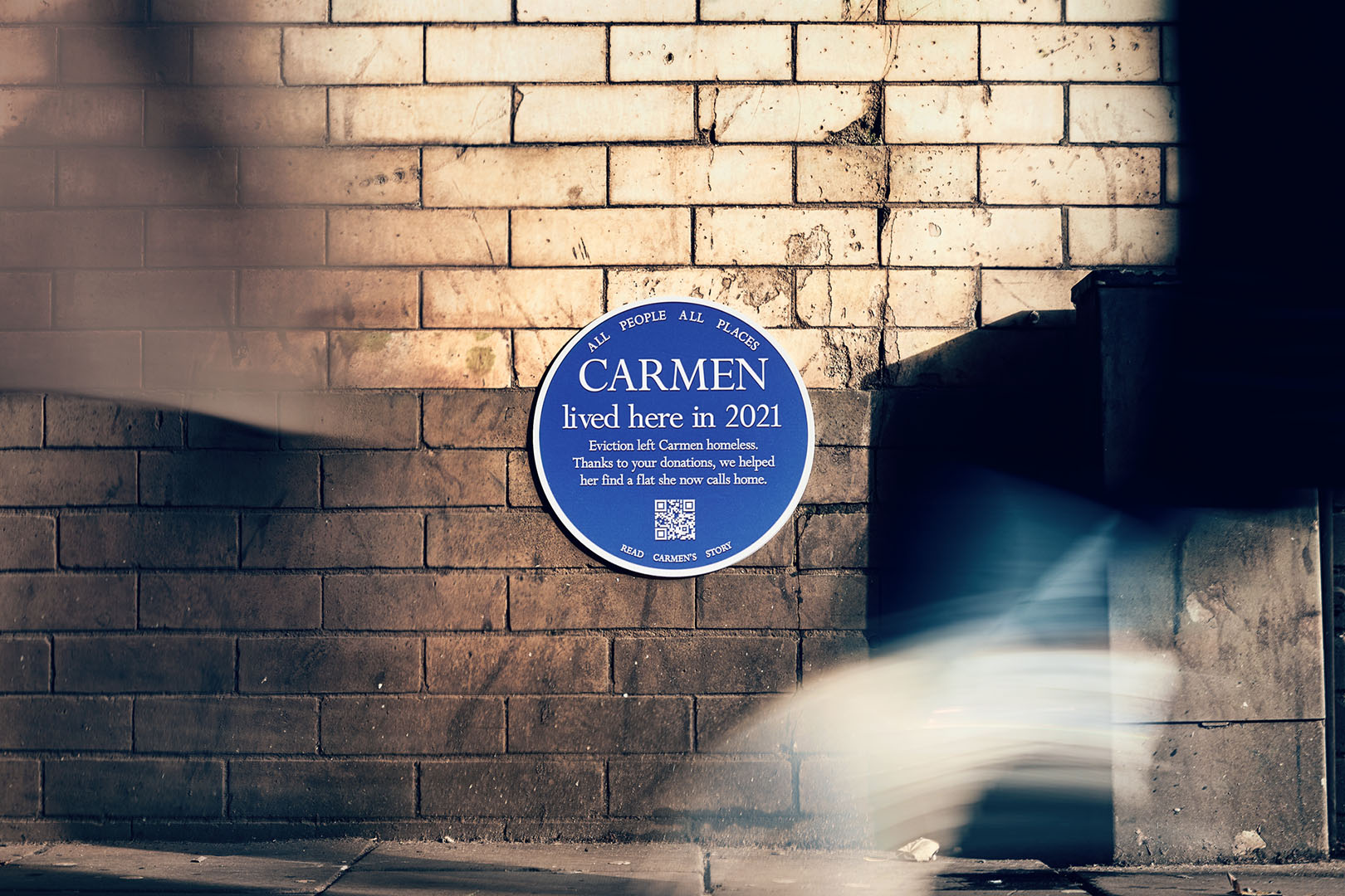 A blue plaque on a wall that says 'Carmen lived here in 2021'