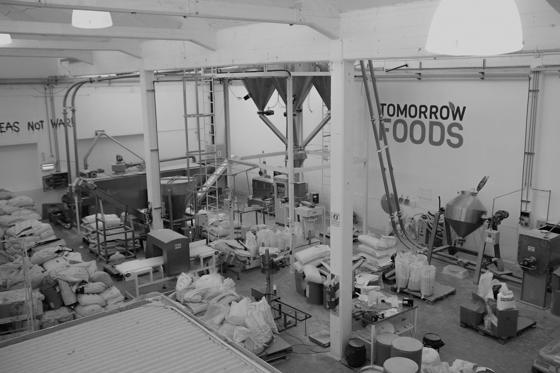 Wide view of a modern food processing facility with machinery, conveyors, and ingredient bags.