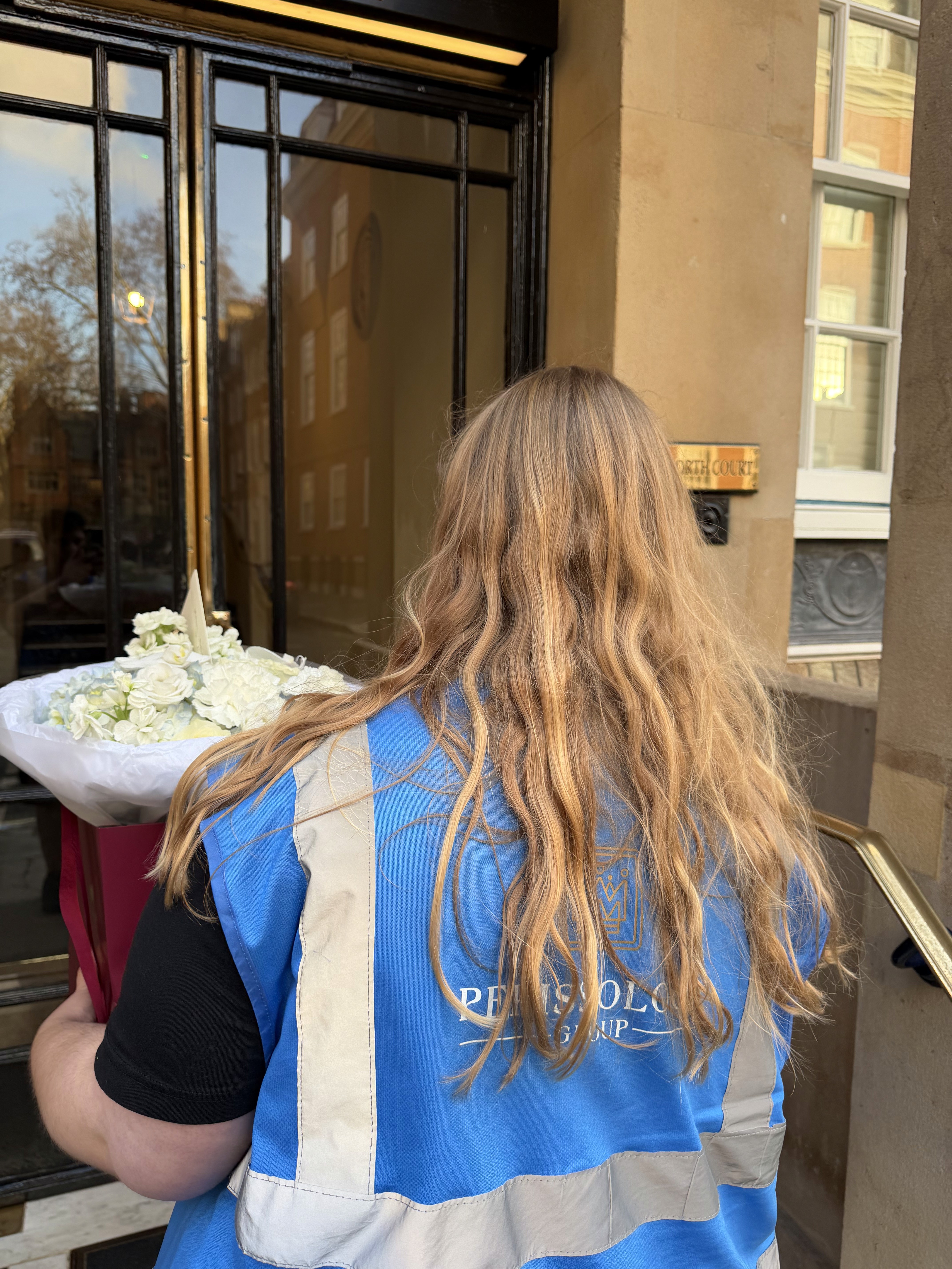 Courier Caitlin delivering flowers in a concierge-style setting
