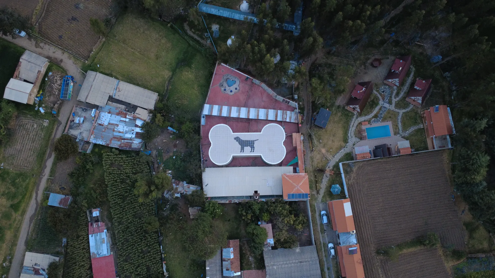 Vue aérienne du refuge pour chiens de Carhuaz au Pérou, avec le toit rouge peint d'un chien et d'un os en blanc