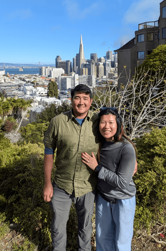 Two gold wedding rings rest atop a soft, textured fabric with a subtle pattern. The rings shine under gentle light, evoking themes of love and commitment.