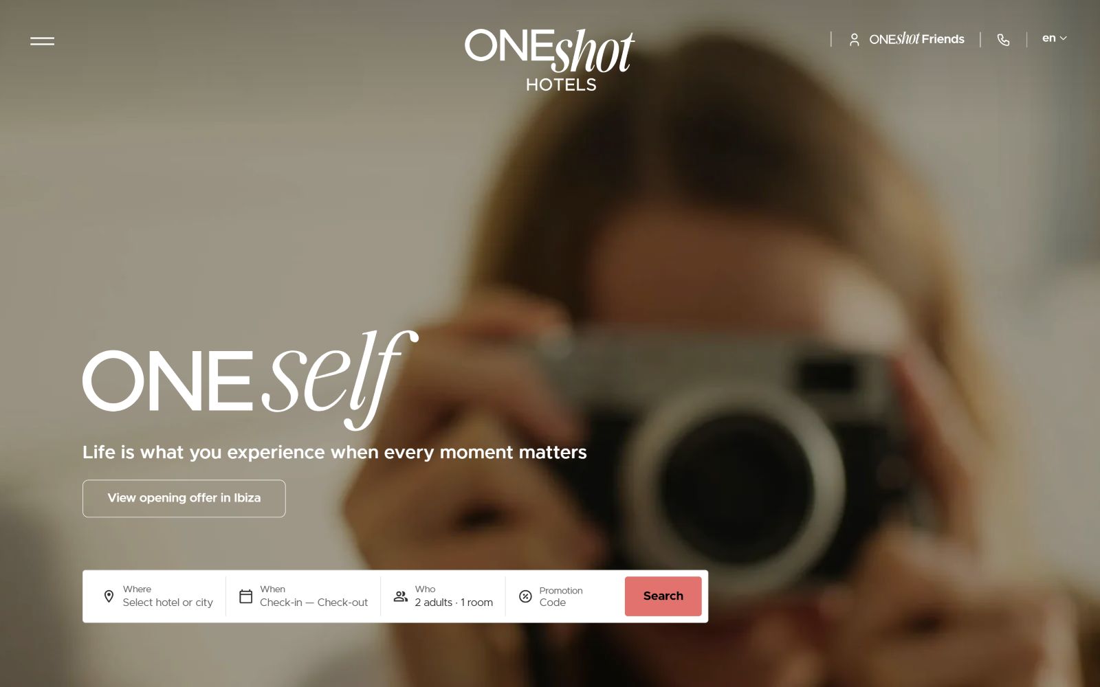 Blurry person taking a photo with a camera. Text: "ONEself. Life is what you experience when every moment matters.