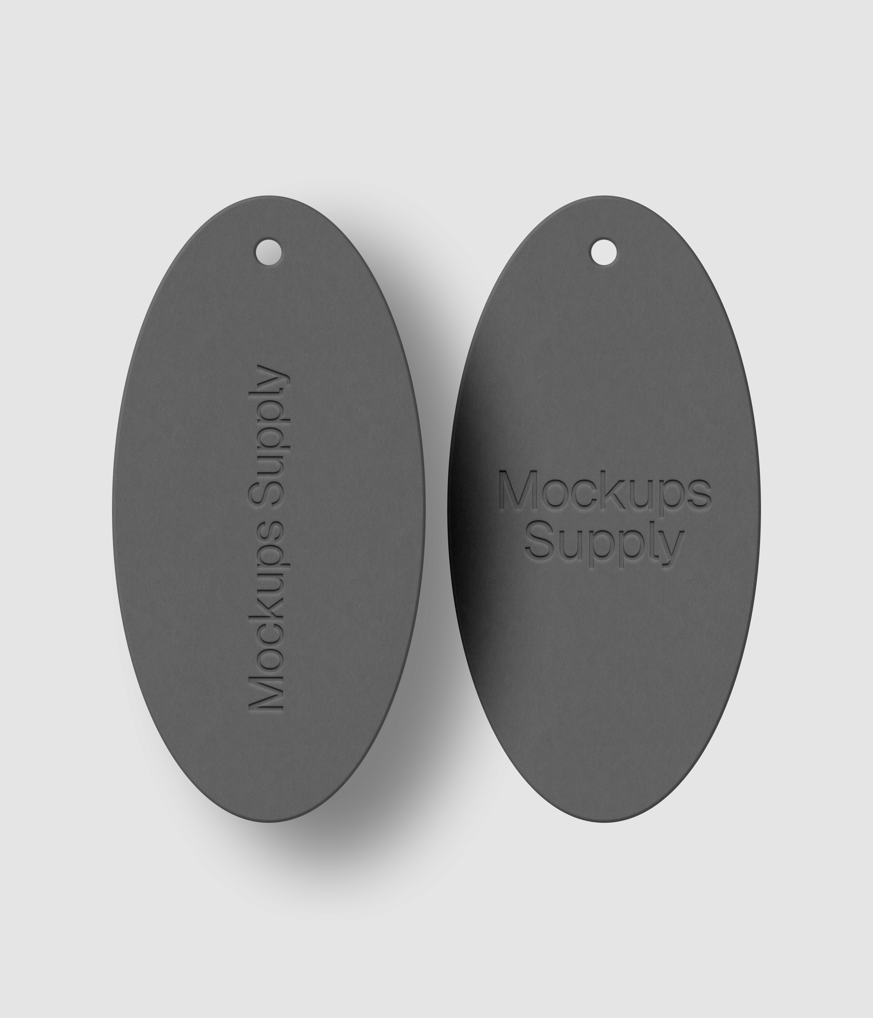 Pair of white elongated oval tags featuring letterpress pressed logo with drop shadow detail for clean branding presentation mockup