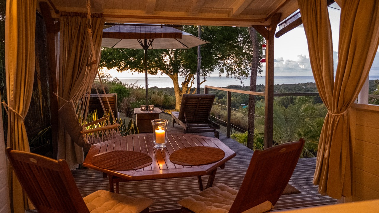 Terrasse privée du Lodge Rosewood avec vue sur la mer des caraïbes au coucher de soleil